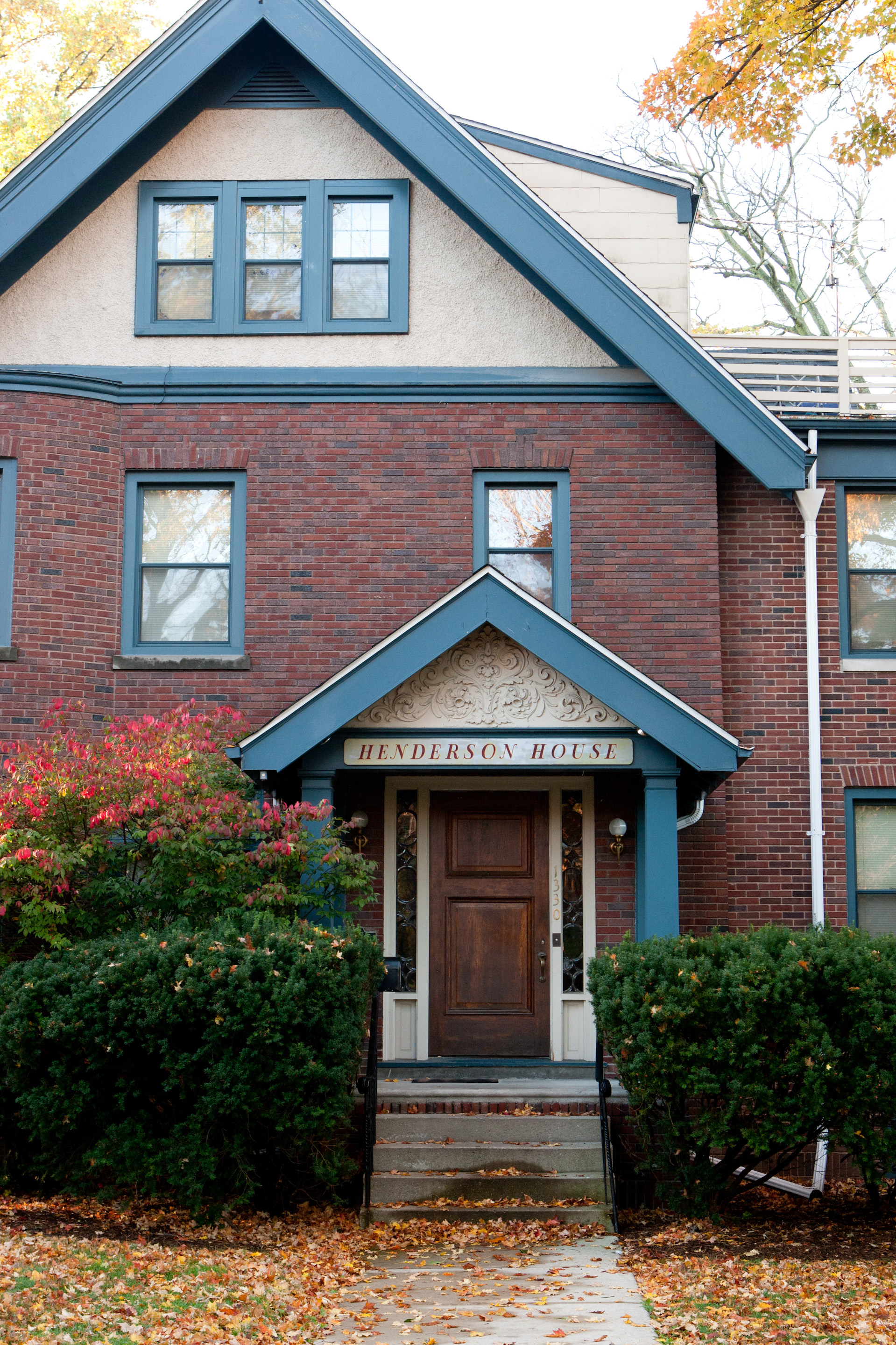 Front view of Henderson House, which is a brick building with blue trim