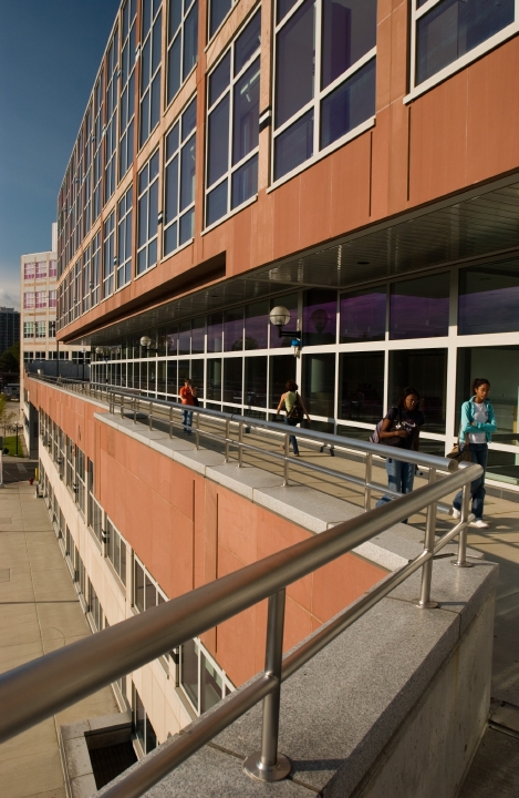 A walkway on the side of the terracotta facade of Mary Sue Coleman Hall