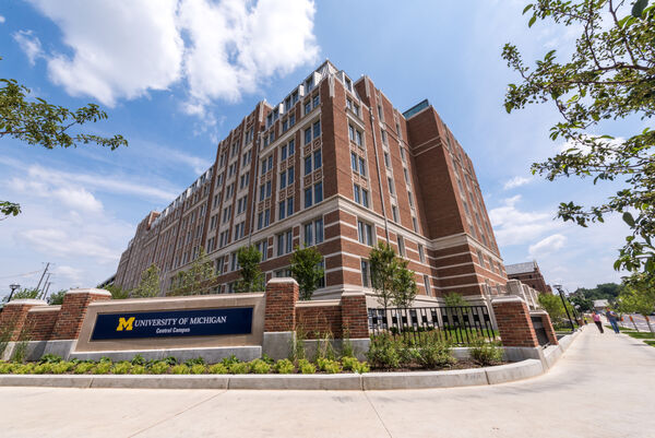 Looking up at the tall brick Munger Graduate Residences building on a sunny day
