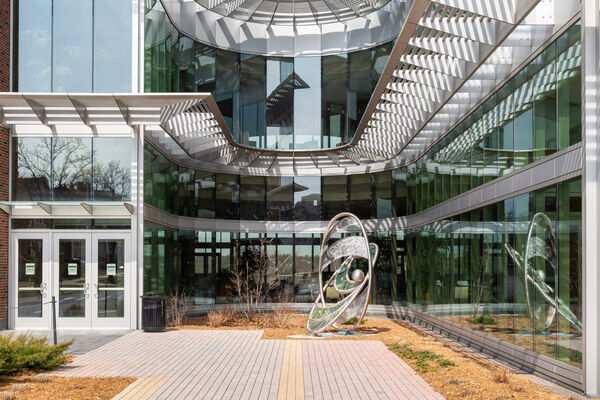 The exterior of the School of Nursing with walls of glass windows and decorative metal awnings