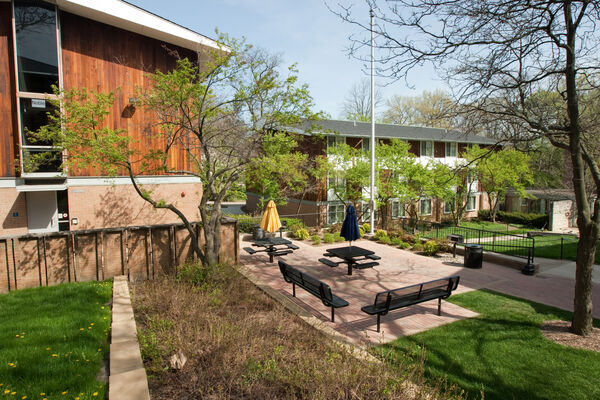A courtyard with benches and umbrella tables