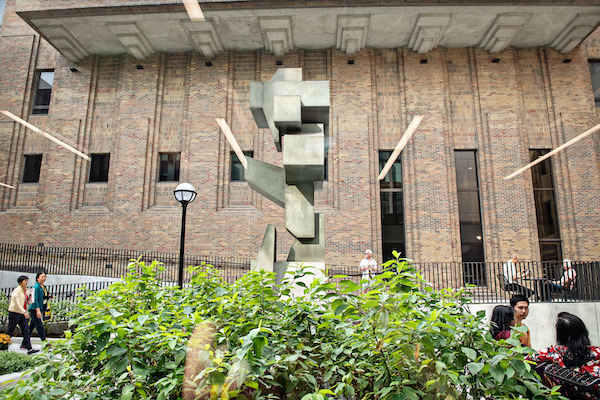 A blocky, grey cement sculpture in the School of Dentistry courtyard