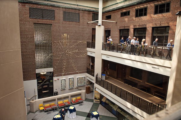 People walking on the third floor walkway in an atrium